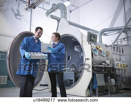 Stock Photo - Scientists with product and vacuum tank. Fotosearch