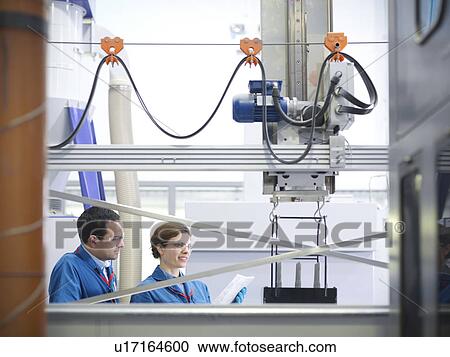 Stock Image - Scientists with product being processed. Fotosearch