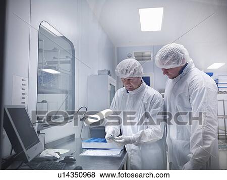 Stock Photo - Scientists with product in clean room. Fotosearch