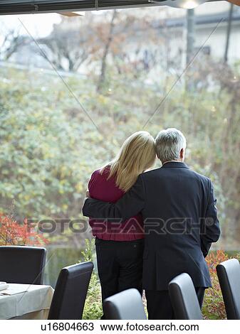 Senior Couple having an intimate moment in a restaurant whilst looking out a window View Large Photo Image Stock Image - Senior Couple having an intimate moment in a restaurant whilst looking out a window. Fotosearch