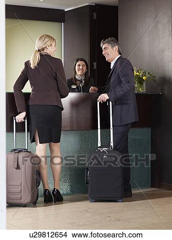 Senior couple sharing a joke at front desk of a Hotel View Large Photo Image Picture - Senior couple sharing a joke at front desk of a Hotel. Fotosearch