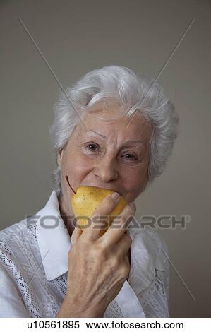 Senior Woman eating a pear View Large Photo Image Stock Photography - Senior Woman eating a pear. Fotosearch