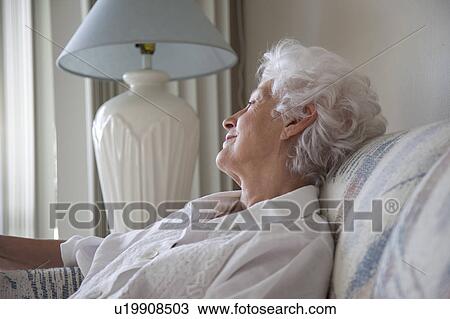 Senior Woman relaxing on a sofa View Large Photo Image Stock Image - Senior Woman relaxing on a sofa. Fotosearch