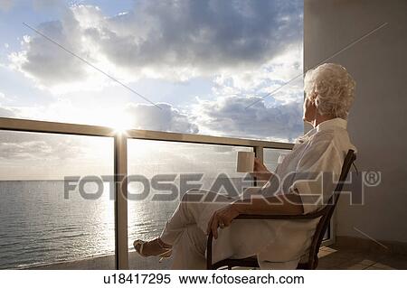 Stock Photography - Senior Woman watching sunrise. Fotosearch