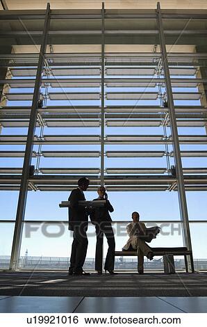 Stock Photograph - shillouete of buisness people in a corridor. Fotosearch