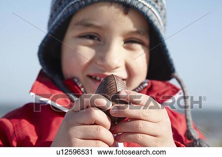 Smiling boy with chocolate egg outside View Large Photo Image Stock Image - Smiling boy with chocolate egg outside. Fotosearch