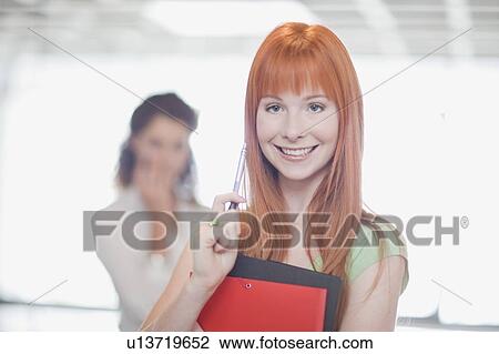 Smiling businesswoman holding folders View Large Photo Image Stock Image - Smiling businesswoman holding folders. Fotosearch