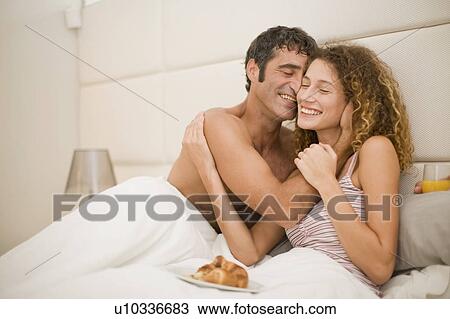 Smiling couple having breakfast in bed View Large Photo Image Stock Image - Smiling couple having breakfast in bed. Fotosearch