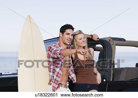Smiling couple hugging by jeep View Large Photo Image Stock Image - Smiling couple hugging by jeep. Fotosearch