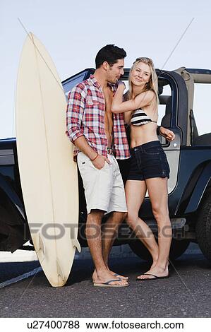Smiling couple hugging by jeep View Large Photo Image Stock Photo - Smiling couple hugging by jeep. Fotosearch