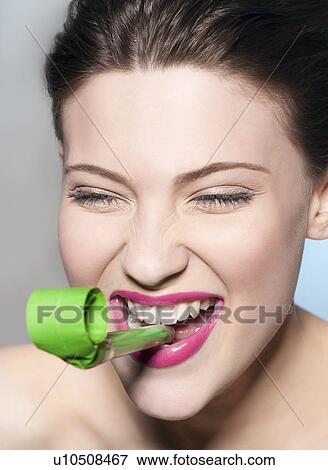 Stock Photo - Smiling woman blowing noisemaker. Fotosearch