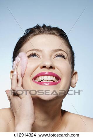 Smiling woman cleansing her face View Large Photo Image Picture - Smiling woman cleansing her face. Fotosearch