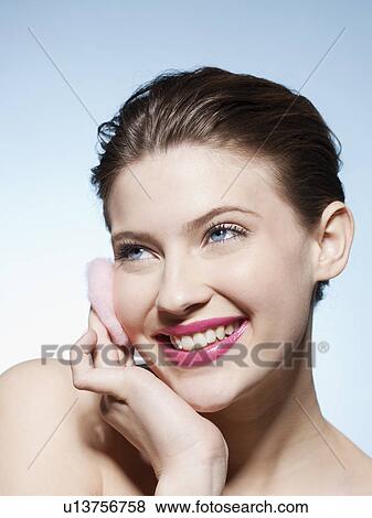 Smiling woman cleansing her face View Large Photo Image Stock Photo - Smiling woman cleansing her face. Fotosearch