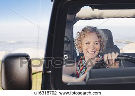 Smiling woman driving jeep View Large Photo Image Stock Image - Smiling woman driving jeep. Fotosearch