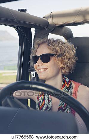 Smiling woman driving jeep View Large Photo Image Stock Photo - Smiling woman driving jeep. Fotosearch