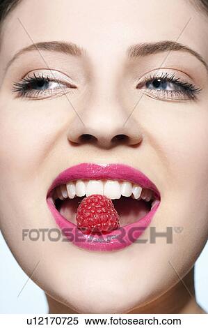Smiling woman eating a raspberry View Large Photo Image Stock Photography - Smiling woman eating a raspberry. Fotosearch