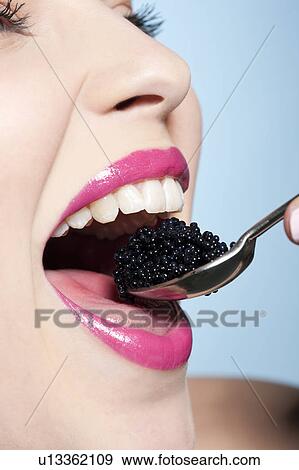 Smiling woman eating caviar View Large Photo Image Stock Photo - Smiling woman eating caviar. Fotosearch