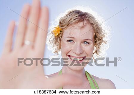 Picture - Smiling woman holding up hand. Fotosearch