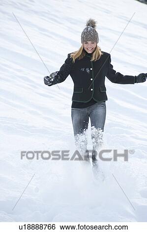 Smiling woman kicking snow outdoors View Large Photo Image Stock Photograph - Smiling woman kicking snow outdoors. Fotosearch