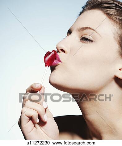 Smiling woman kissing lollipop View Large Photo Image Stock Image - Smiling woman kissing lollipop. Fotosearch