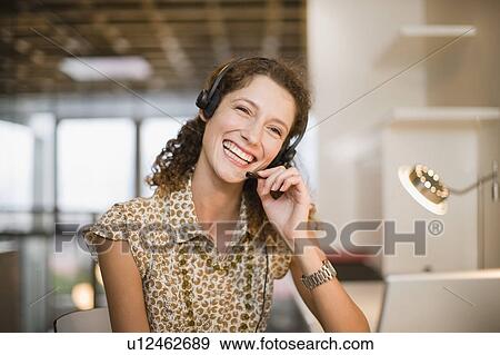 Stock Photo - Smiling woman wearing headset. Fotosearch