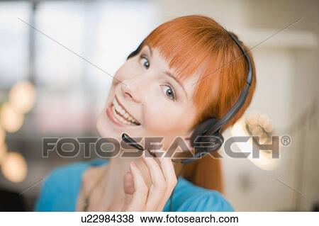 Stock Photo - Smiling woman wearing headset. Fotosearch