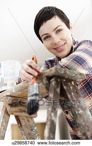 Stock Image - Smiling woman with paintbrush. Fotosearch