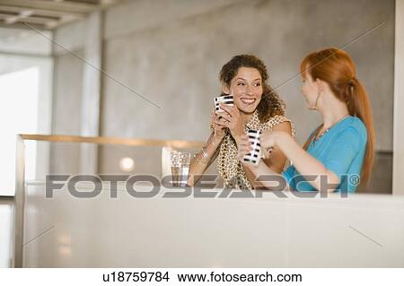 Smiling women having coffee together View Large Photo Image Picture - Smiling women having coffee together. Fotosearch