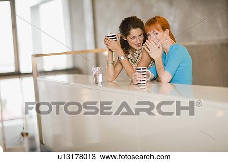 Smiling women whispering together View Large Photo Image Stock Image - Smiling women whispering together. Fotosearch