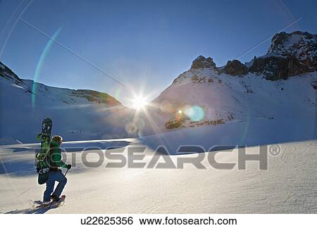 Snowshoe walker at dawn with snowboard View Large Photo Image Stock Photograph - Snowshoe walker at dawn with snowboard. Fotosearch
