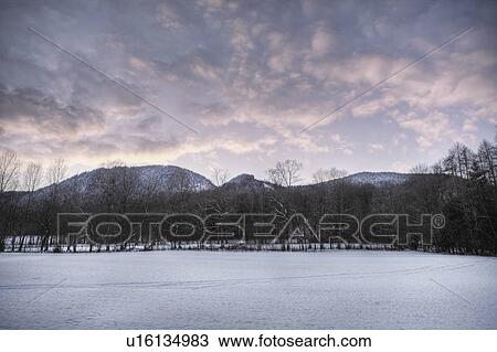 Stock Image - Snowy field with mountains. Fotosearch