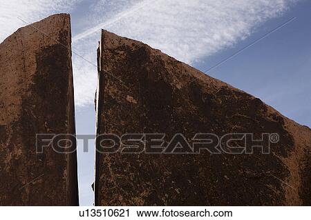 Stock Image - Split rock with blue sky. Fotosearch