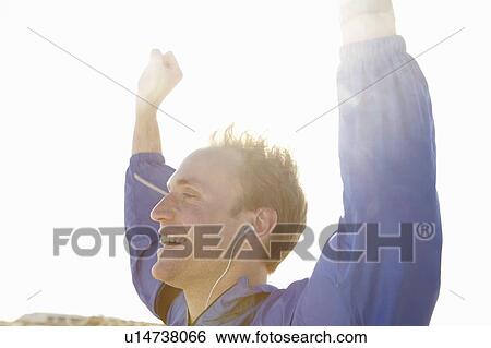 Stock Photograph - Sporty young man celebrating in the sun. Fotosearch