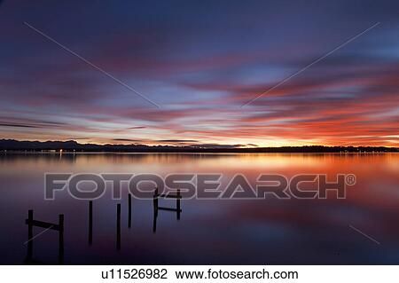 Stock Image - Still lake under dramatic sky. Fotosearch