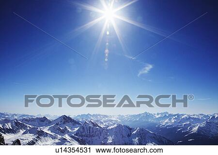 Sun over snow covered mountains View Large Photo Image Stock Image - Sun over snow covered mountains. Fotosearch