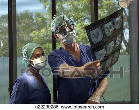 Stock Photograph - Surgeon and nurse with x-ray. Fotosearch