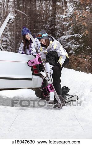 Stock Image - Teen girls going snowboarding. Fotosearch