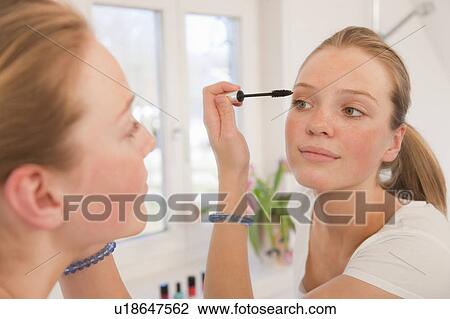 Stock Image - Teenage girl applying mascara. Fotosearch
