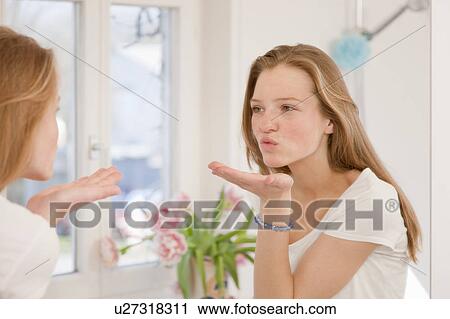 Teenage girl blowing kiss in mirror View Large Photo Image Stock Image - Teenage girl blowing kiss in mirror. Fotosearch