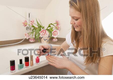 Teenage girl painting her nails View Large Photo Image Picture - Teenage girl painting her nails. Fotosearch