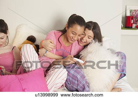 teenage girl reading magazine sitting on her bed View Large Photo Image Stock Photo - teenage girl reading magazine sitting on her bed. Fotosearch