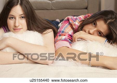 teenage girls lying on cushions at home View Large Photo Image Stock Image - teenage girls lying on cushions at home . Fotosearch