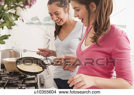 Picture - teenage girls making pancakes. Fotosearch