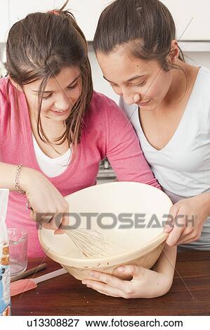 Stock Photo - teenage girls preparing food in kitchen. Fotosearch