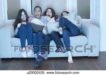 teenage girls watching tv on sofa View Large Photo Image Stock Photography - teenage girls watching tv on sofa. Fotosearch