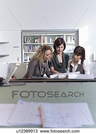 Stock Image - Three architects working in an office. Fotosearch