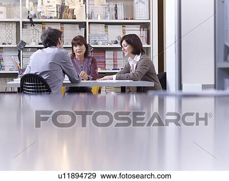 Three colleagues having a meeting View Large Photo Image Stock Photo - Three colleagues having a meeting. Fotosearch