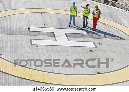 Three workers on helideck View Large Photo Image Stock Photo - Three workers on helideck. Fotosearch