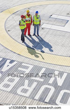 Three workers on helideck View Large Photo Image Stock Photo - Three workers on helideck. Fotosearch