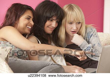 Three young women with laptop computer View Large Photo Image Stock Photo - Three young women with laptop computer. Fotosearch